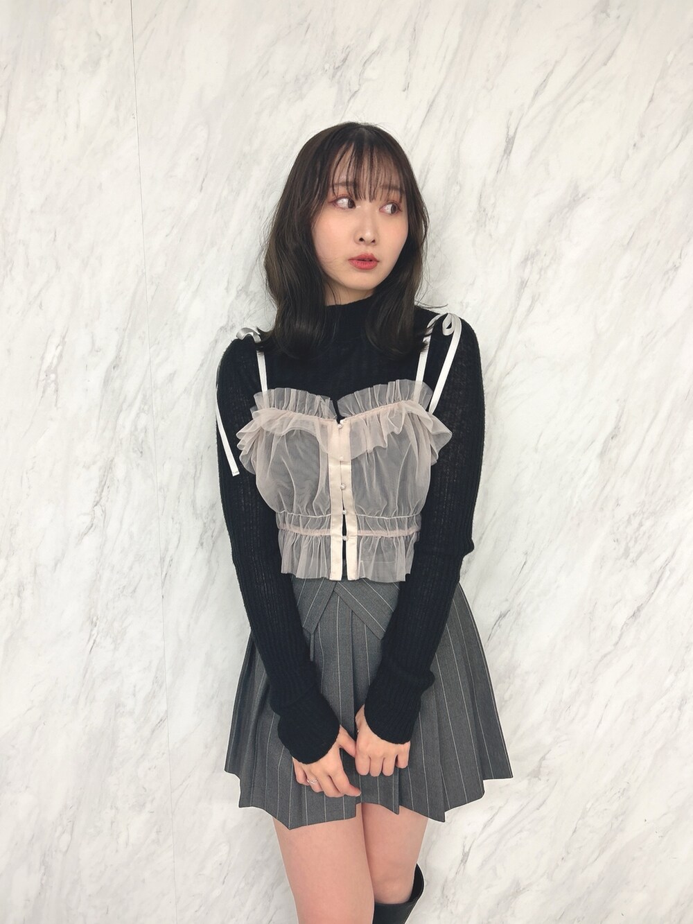 ピンク系のキャミソール、ブラック系のニット/セーター、グレー系のスカートを着用したレディースの冬コーディネートの4枚目の写真