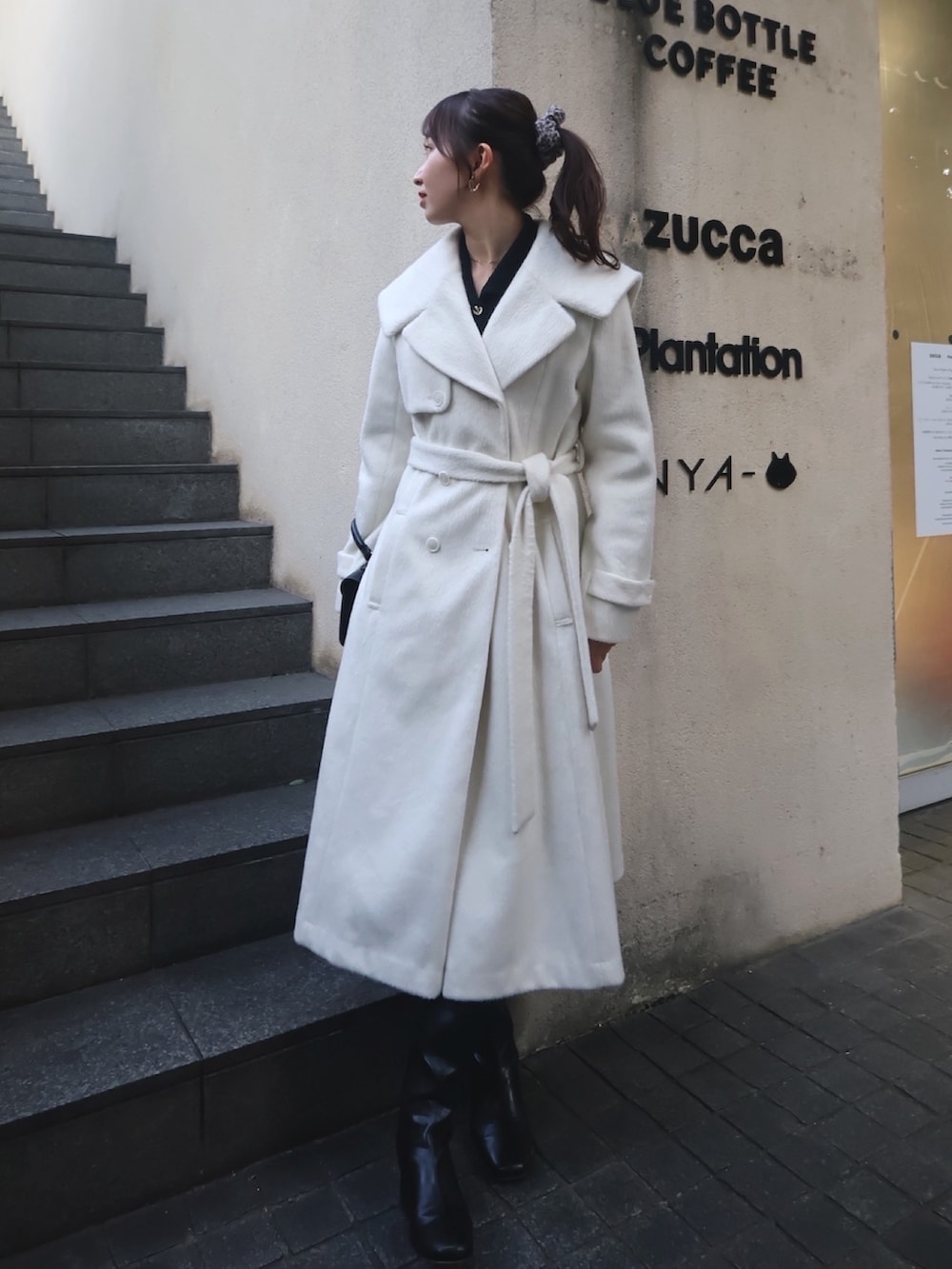 ホワイト系のその他アウター、ブラック系のブーツを着用したレディースの秋コーディネートの2枚目の写真