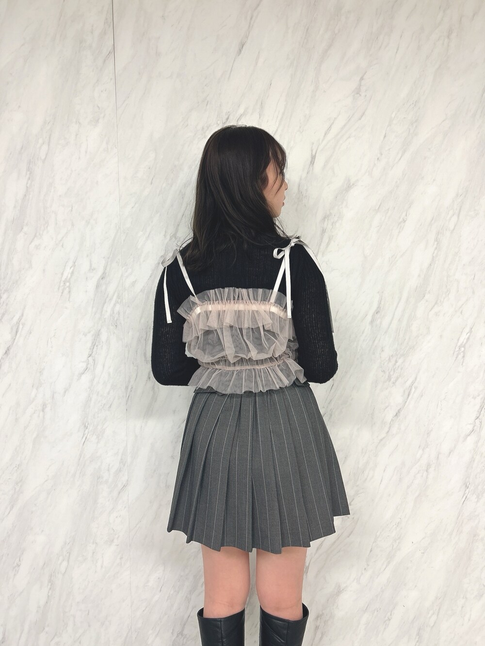 ピンク系のキャミソール、ブラック系のニット/セーター、グレー系のスカートを着用したレディースの冬コーディネートの5枚目の写真