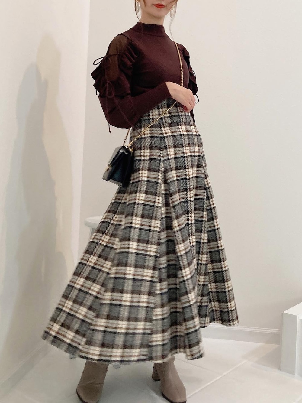 ブラウン系のニット/セーター、その他のスカートを着用したレディースの秋コーディネートの3枚目の写真