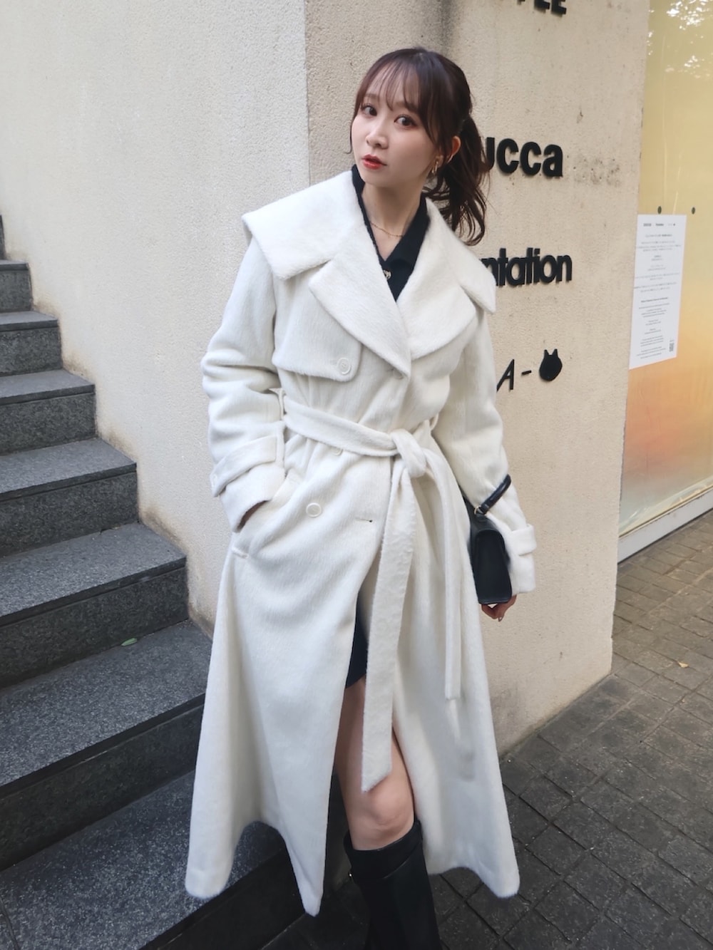 ホワイト系のその他アウター、ブラック系のブーツを着用したレディースの秋コーディネートの5枚目の写真