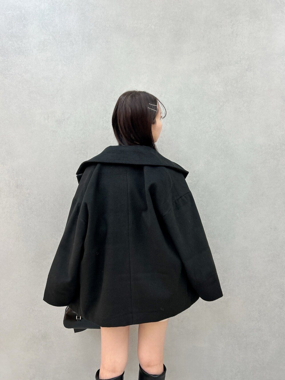 ブラック系のその他アウター、ブラウン系のニット/セーター、ホワイト系のその他パンツを着用したレディースの冬コーディネートの6枚目の写真