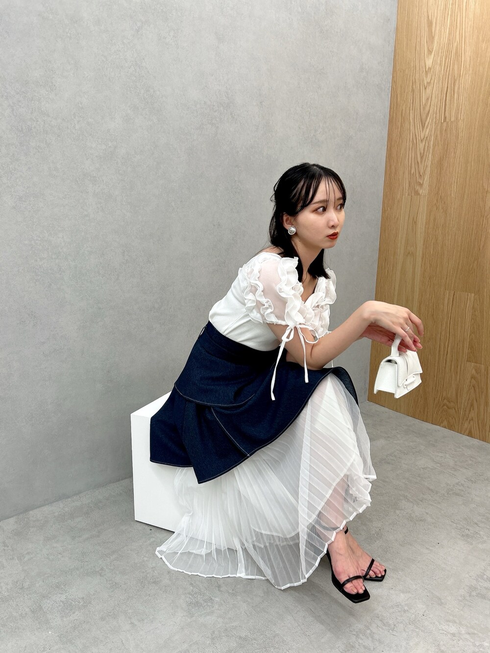 ブルー系のスカート、ホワイト系のTシャツ/カットソーを着用したレディースの夏コーディネートの5枚目の写真