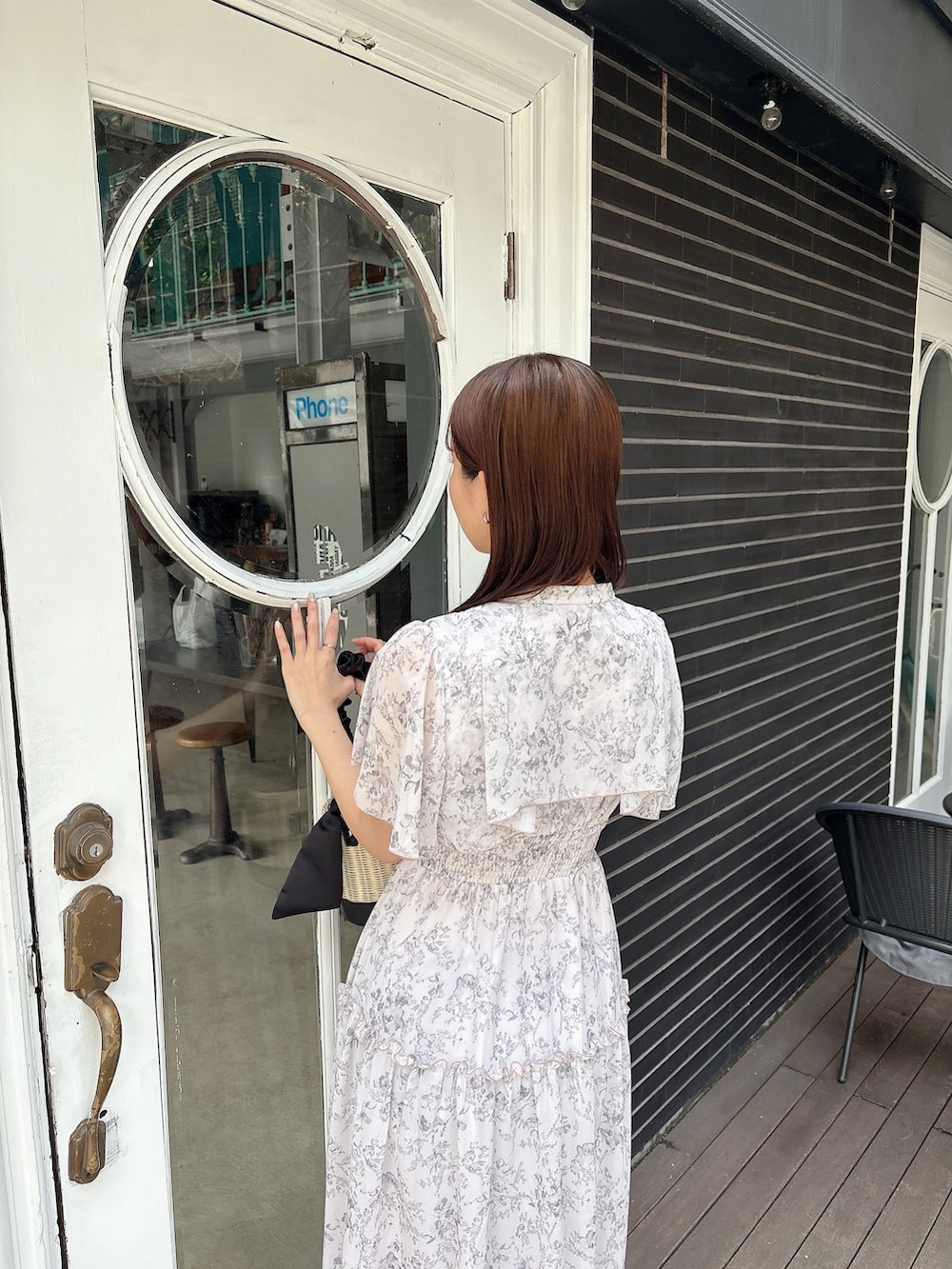 ピンク系のワンピース、ブラック系のかごバッグ、ホワイト系のサンダルを着用したレディースの夏コーディネートの6枚目の写真