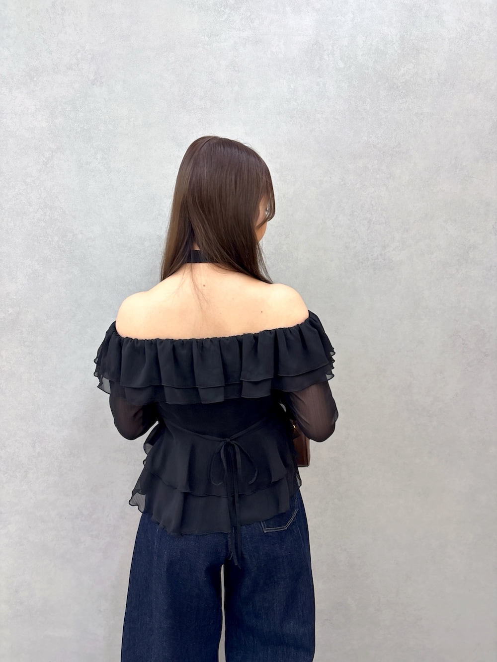 ブラック系のシャツ/ブラウス、ブルー系のデニムパンツ、ブラック系のパンプスを着用したレディースの冬コーディネートの6枚目の写真