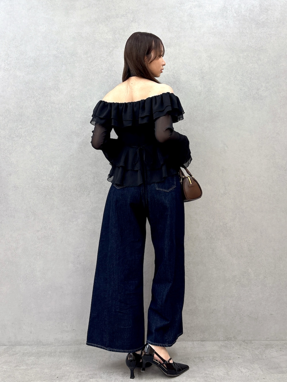 ブラック系のシャツ/ブラウス、ブルー系のデニムパンツ、ブラック系のパンプスを着用したレディースの冬コーディネートの3枚目の写真