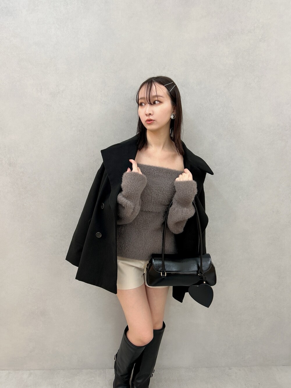 ブラック系のその他アウター、ブラウン系のニット/セーター、ホワイト系のその他パンツを着用したレディースの冬コーディネートの4枚目の写真