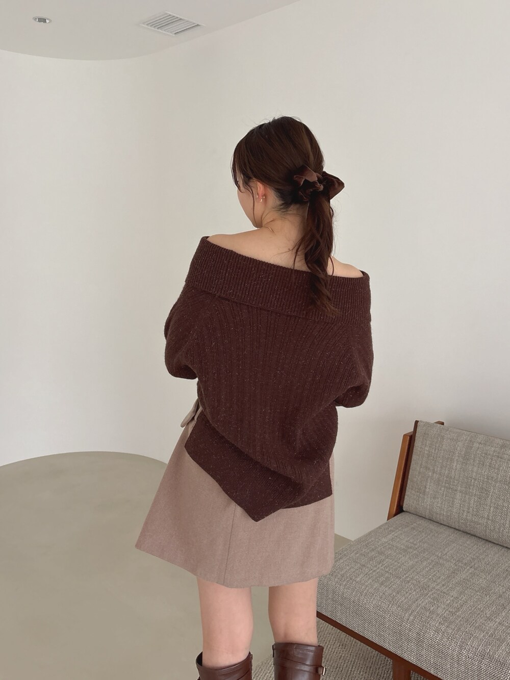 ブラウン系のニット/セーター、ブラウン系のスカート、ブラウン系のブーツを着用したレディースの秋コーディネートの5枚目の写真