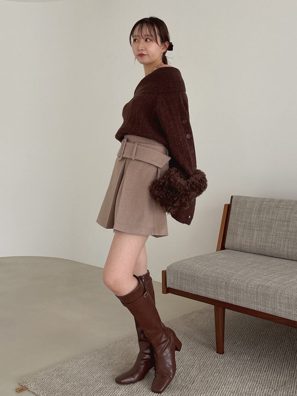 ブラウン系のニット/セーター、ブラウン系のスカート、ブラウン系のブーツを着用したレディースの秋コーディネートの3枚目の写真