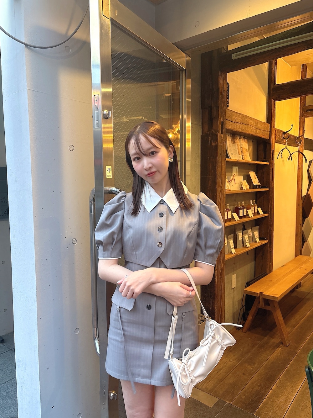 グレー系のワンピース、ホワイト系のハンドバッグを着用したレディースの春コーディネートの3枚目の写真