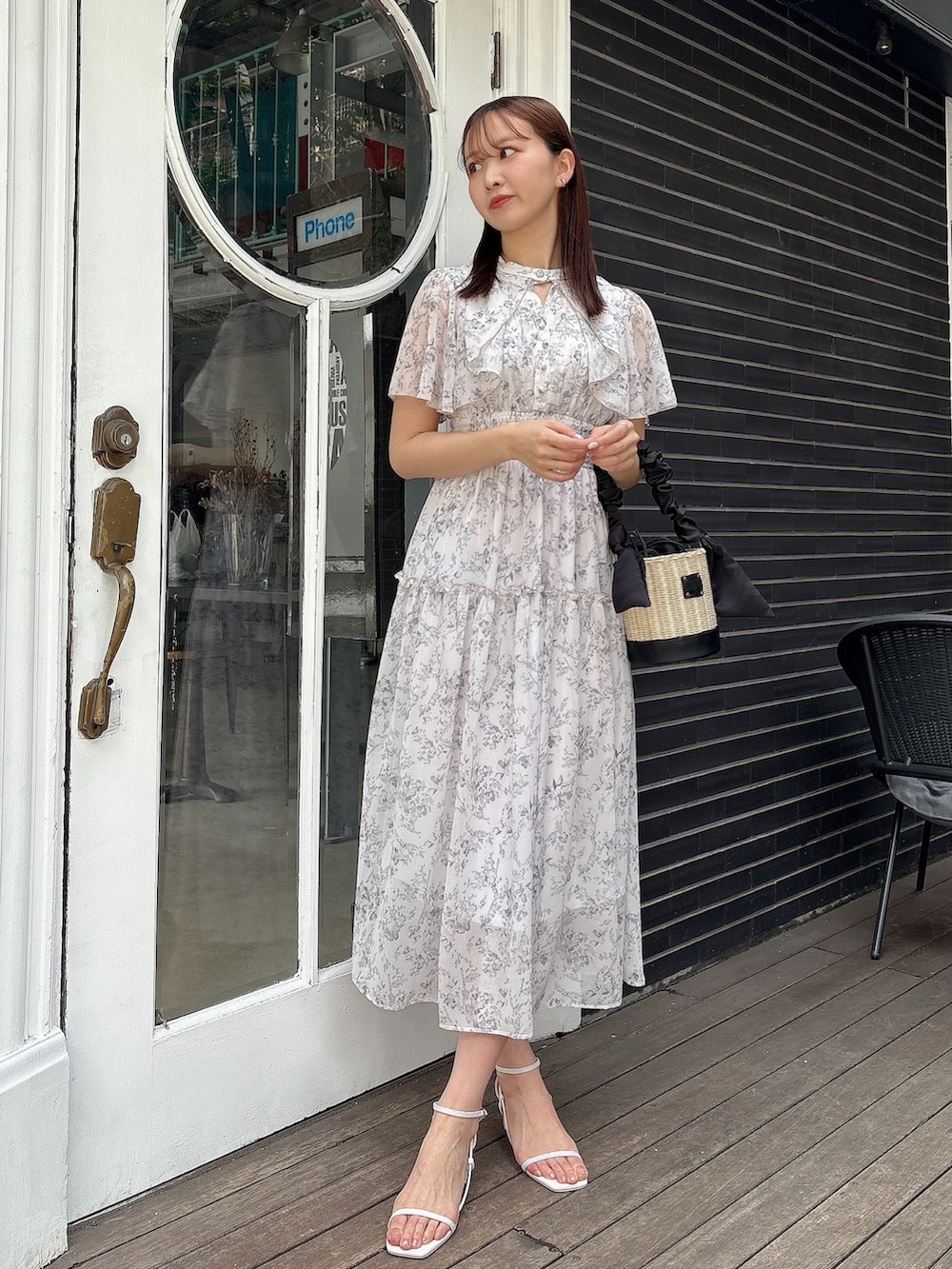 ピンク系のワンピース、ブラック系のかごバッグ、ホワイト系のサンダルを着用したレディースの夏コーディネートの3枚目の写真