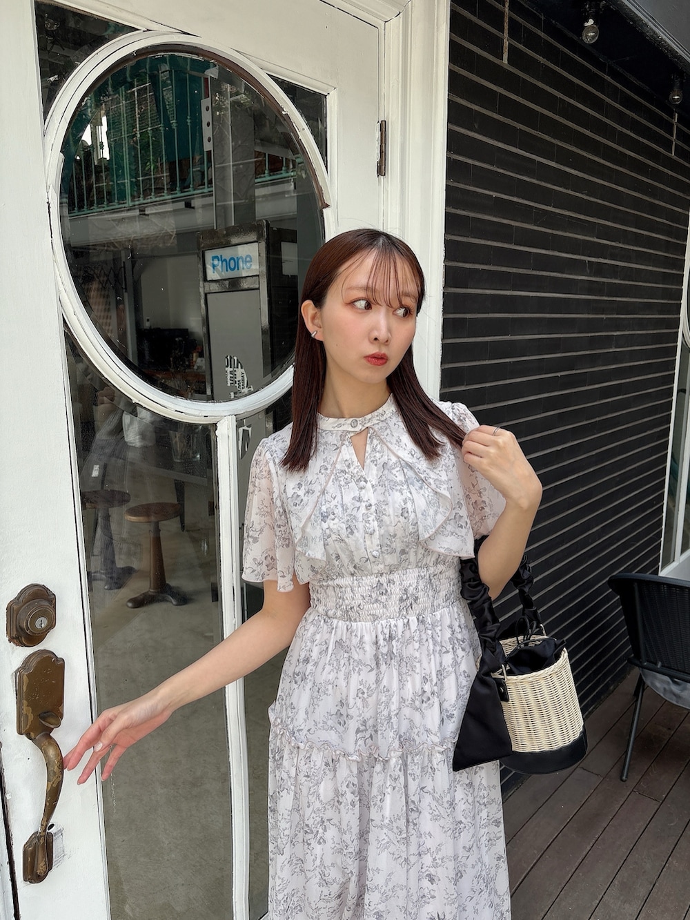 ピンク系のワンピース、ブラック系のかごバッグ、ホワイト系のサンダルを着用したレディースの夏コーディネートの5枚目の写真