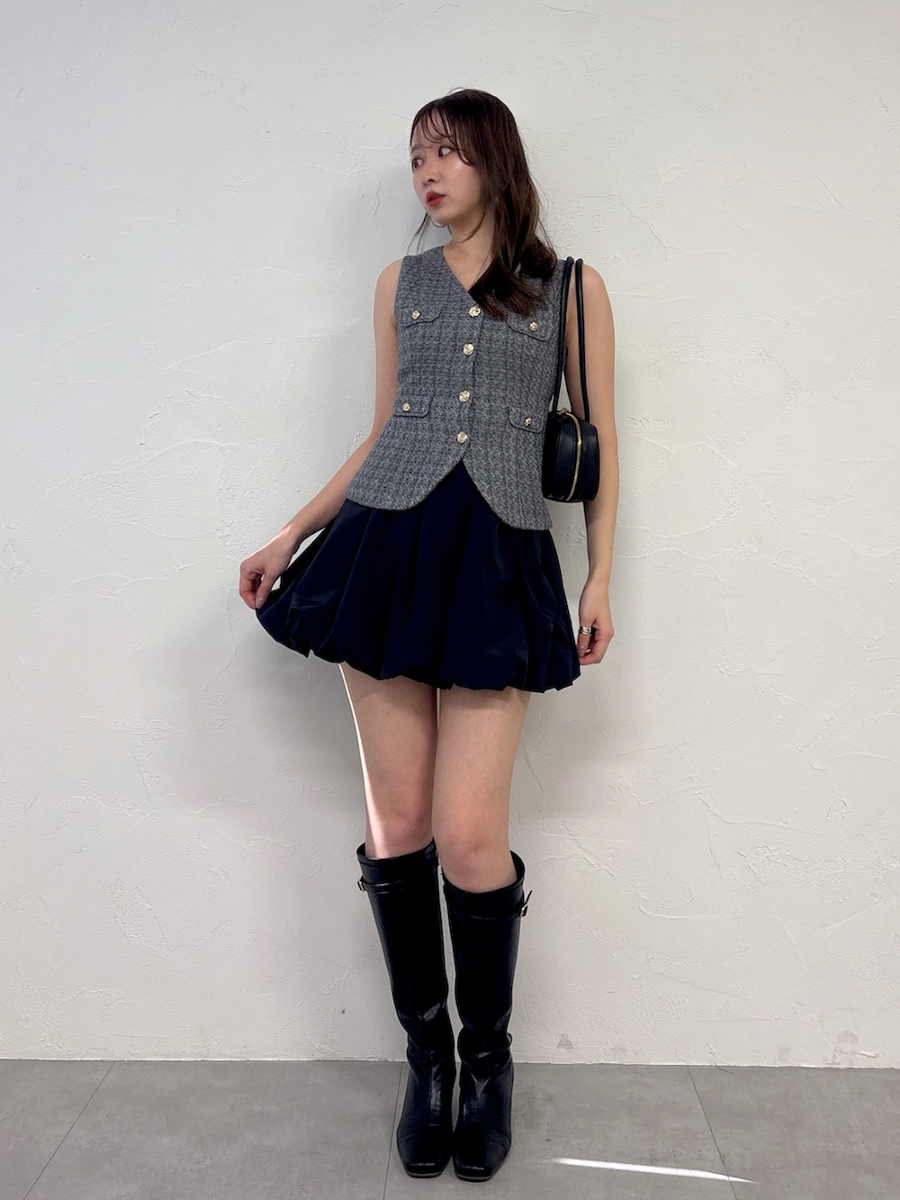 グレー系のワンピース、ブラック系のブーツを着用したレディースの冬コーディネートの2枚目の写真