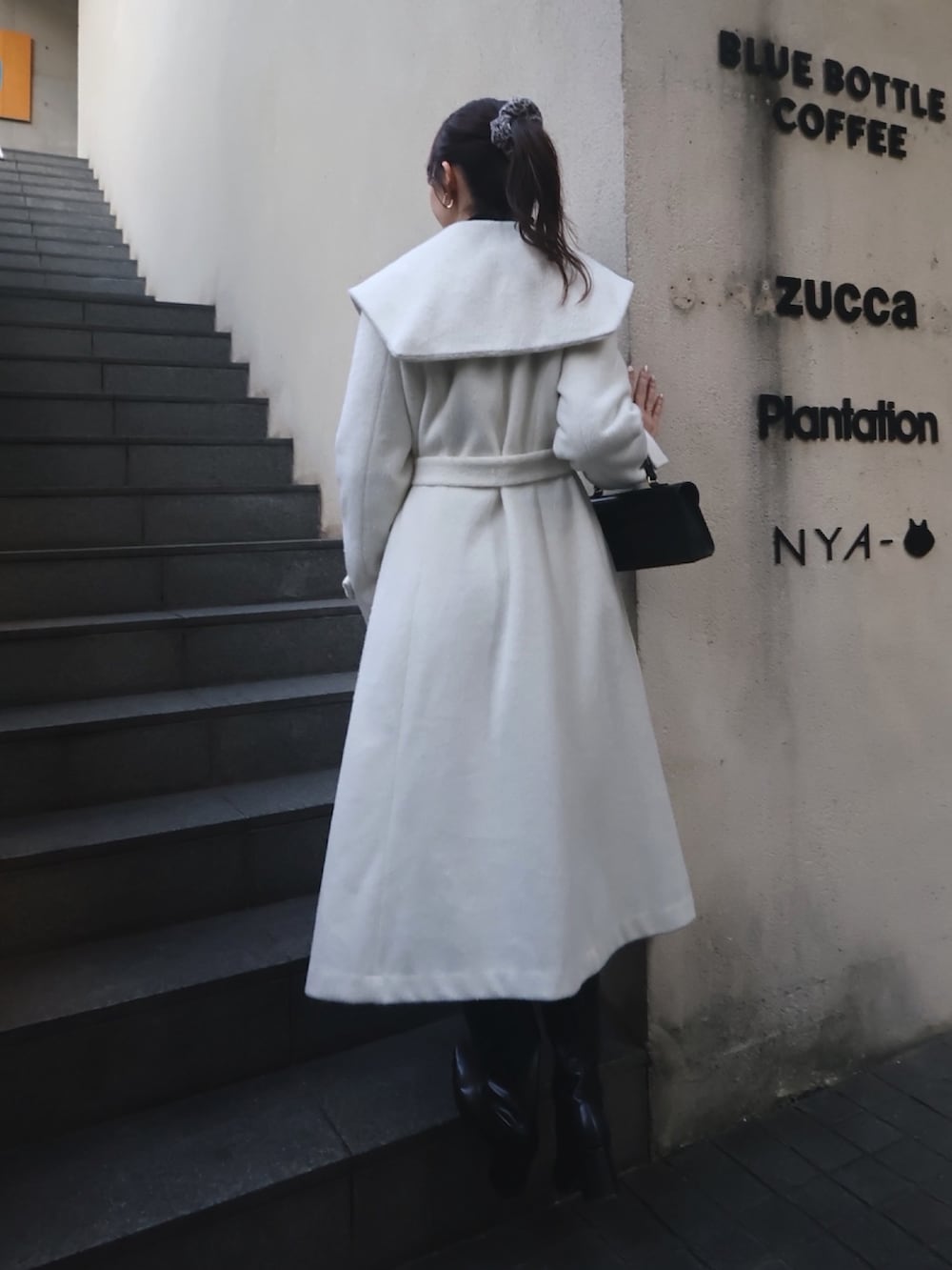 ホワイト系のその他アウター、ブラック系のブーツを着用したレディースの秋コーディネートの3枚目の写真