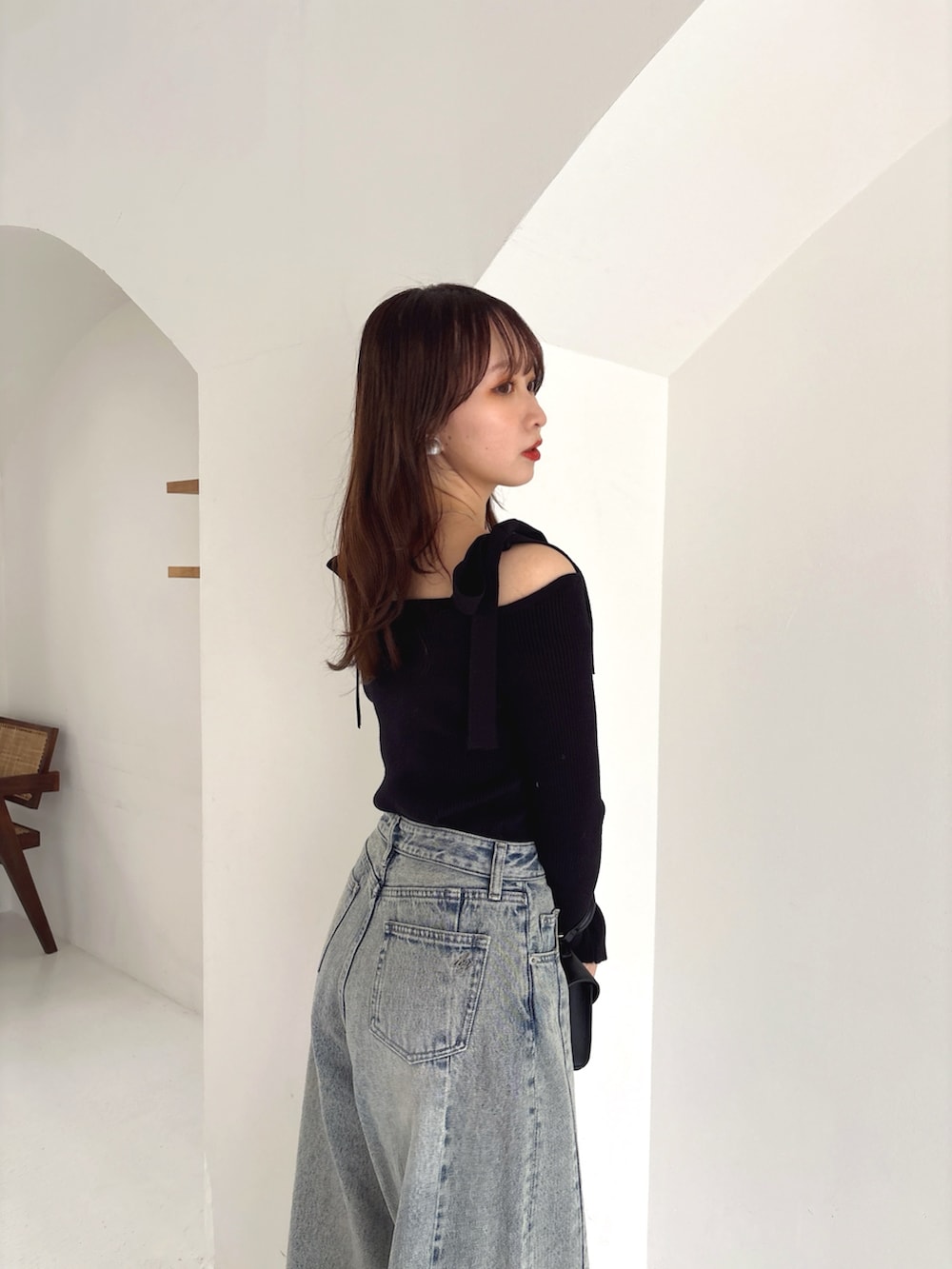 ブラック系のニット/セーター、ブルー系のデニムパンツを着用したレディースの冬コーディネートの5枚目の写真