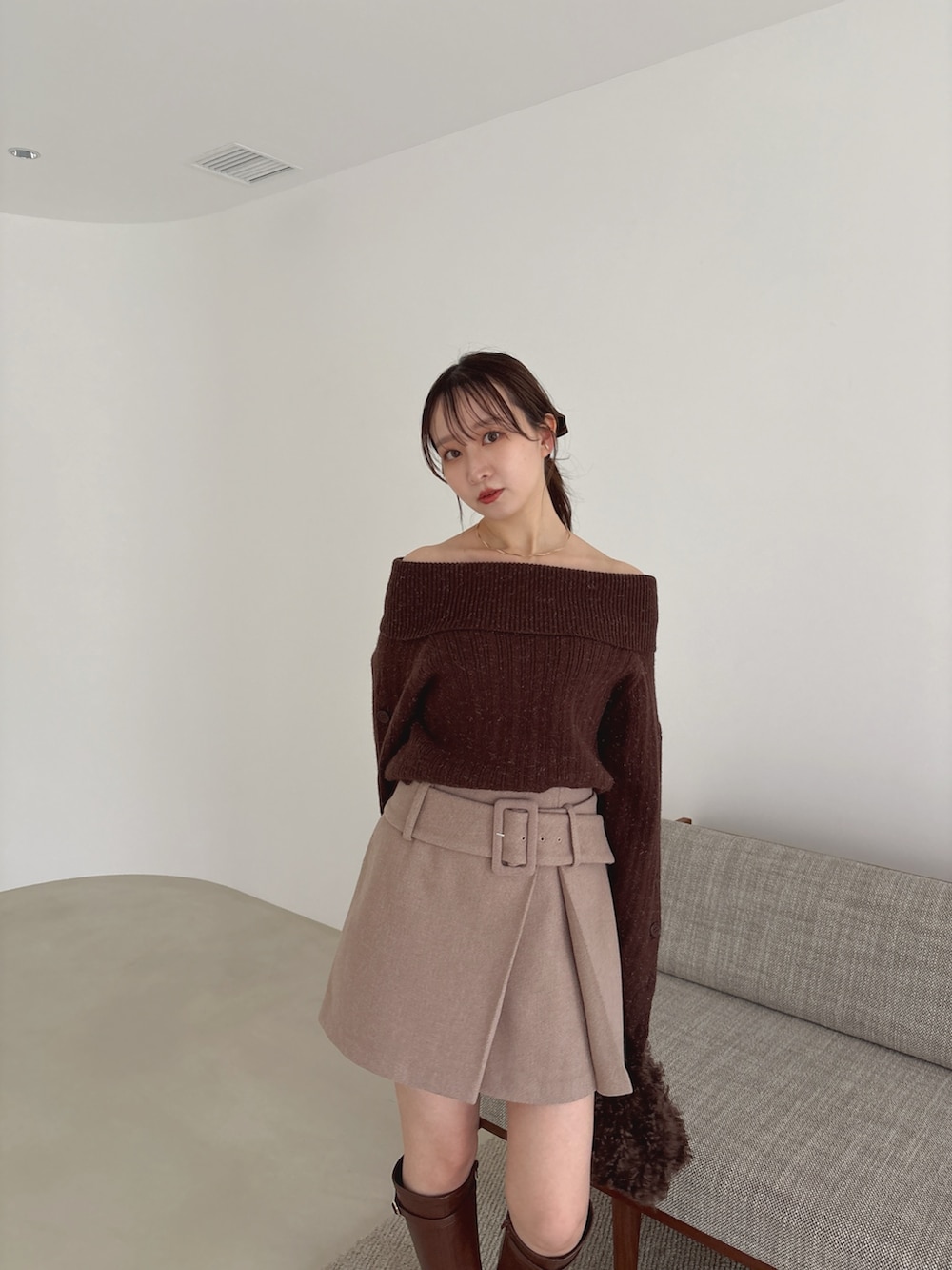 ブラウン系のニット/セーター、ブラウン系のスカート、ブラウン系のブーツを着用したレディースの秋コーディネートの4枚目の写真
