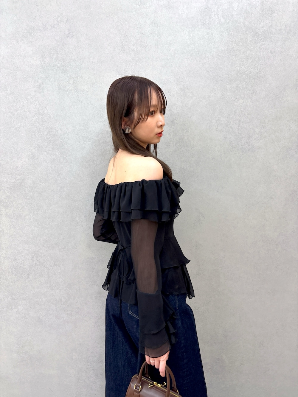 ブラック系のシャツ/ブラウス、ブルー系のデニムパンツ、ブラック系のパンプスを着用したレディースの冬コーディネートの5枚目の写真