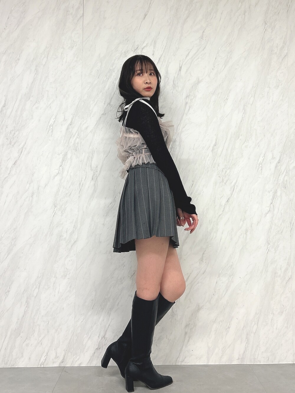 ピンク系のキャミソール、ブラック系のニット/セーター、グレー系のスカートを着用したレディースの冬コーディネートの3枚目の写真