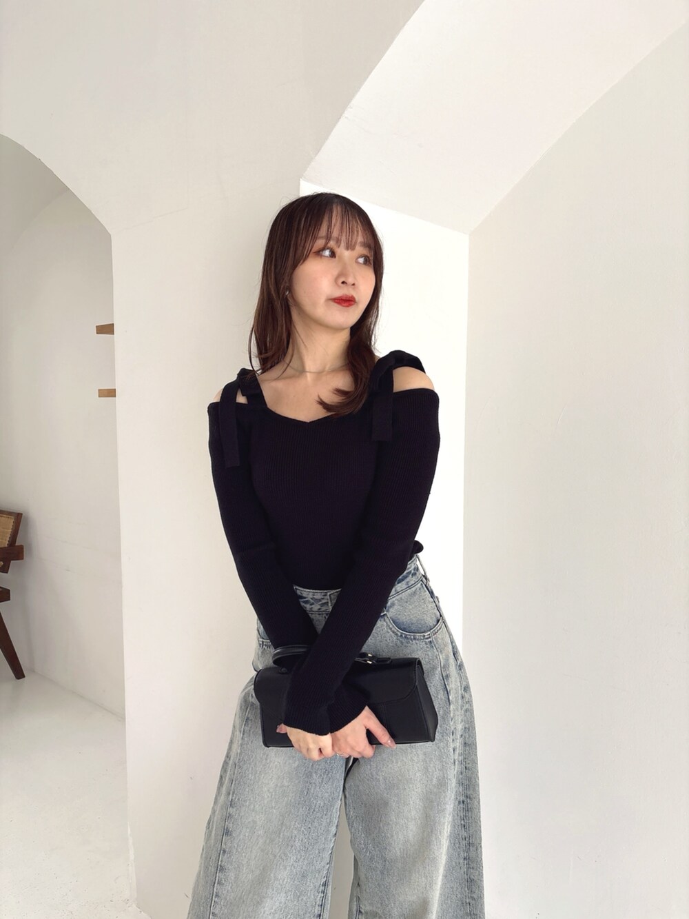 ブラック系のニット/セーター、ブルー系のデニムパンツを着用したレディースの冬コーディネートの3枚目の写真