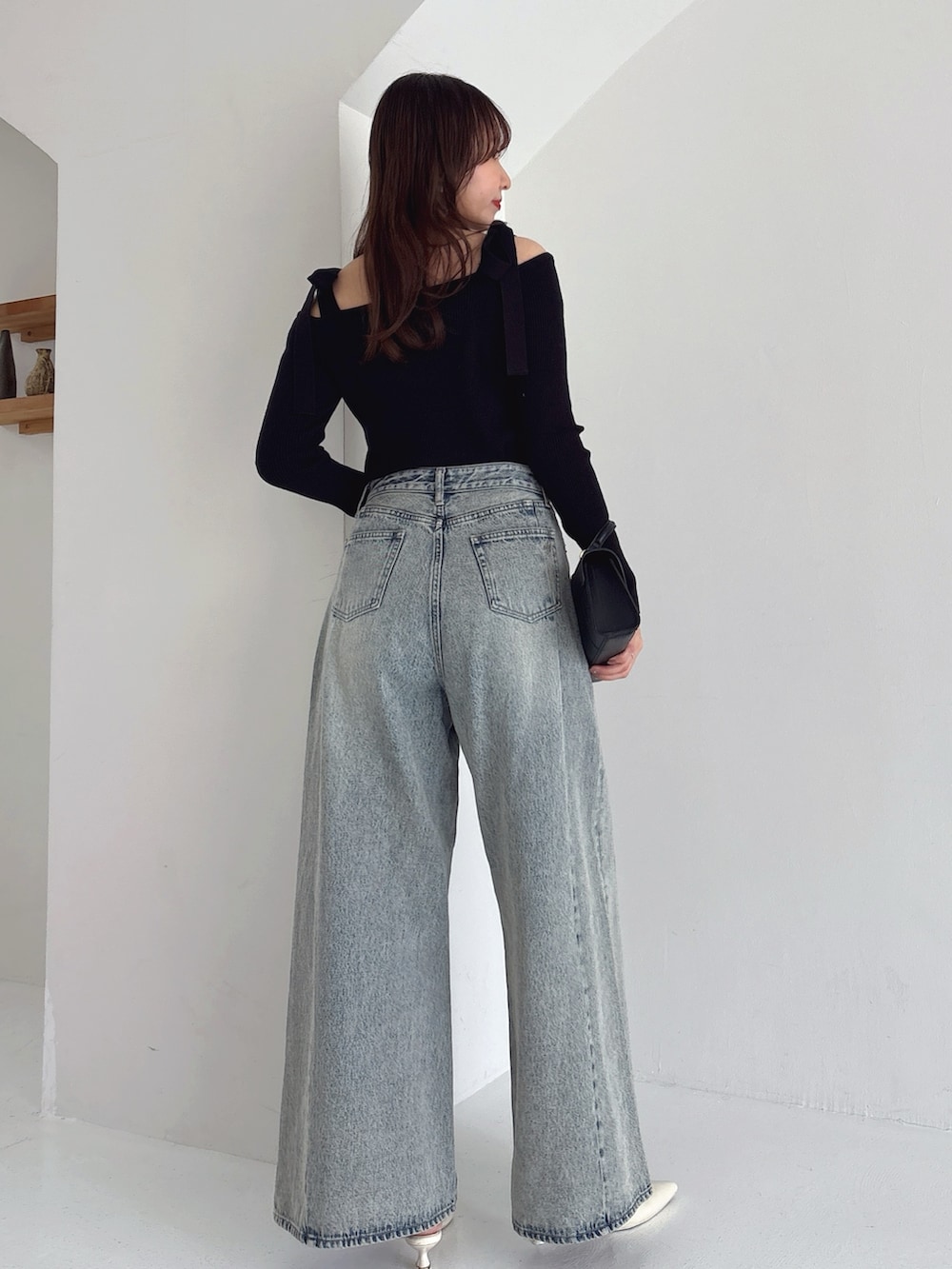 ブラック系のニット/セーター、ブルー系のデニムパンツを着用したレディースの冬コーディネートの2枚目の写真