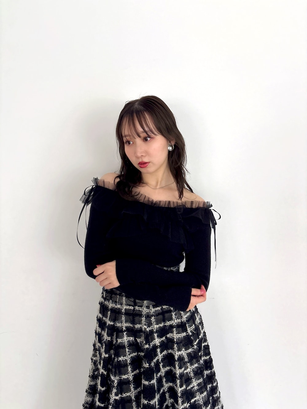 ブラック系のニット/セーター、ブラック系のスカート、ブラック系のブーツを着用したレディースの秋コーディネートの5枚目の写真