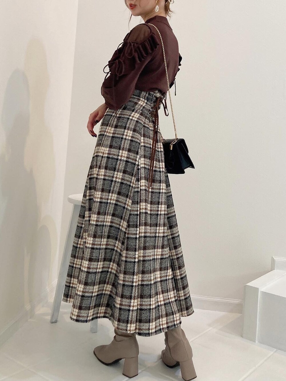 ブラウン系のニット/セーター、その他のスカートを着用したレディースの秋コーディネートの2枚目の写真