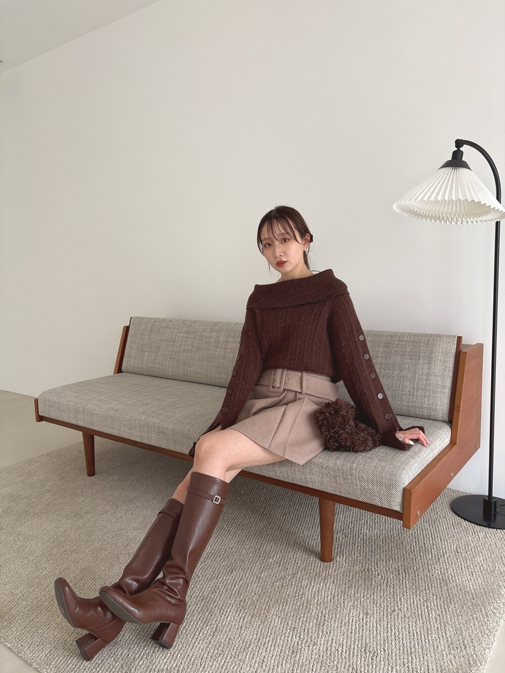 ブラウン系のニット/セーター、ブラウン系のスカート、ブラウン系のブーツを着用したレディースの秋コーディネートの6枚目の写真