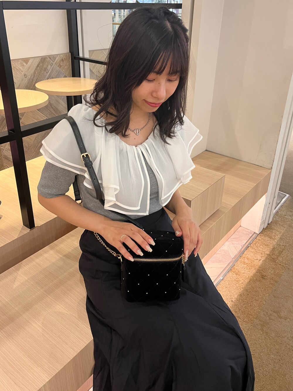 グレー系のTシャツ/カットソー、ブラック系のスカート、ブラック系のサンダルを着用したレディースの夏コーディネートの2枚目の写真