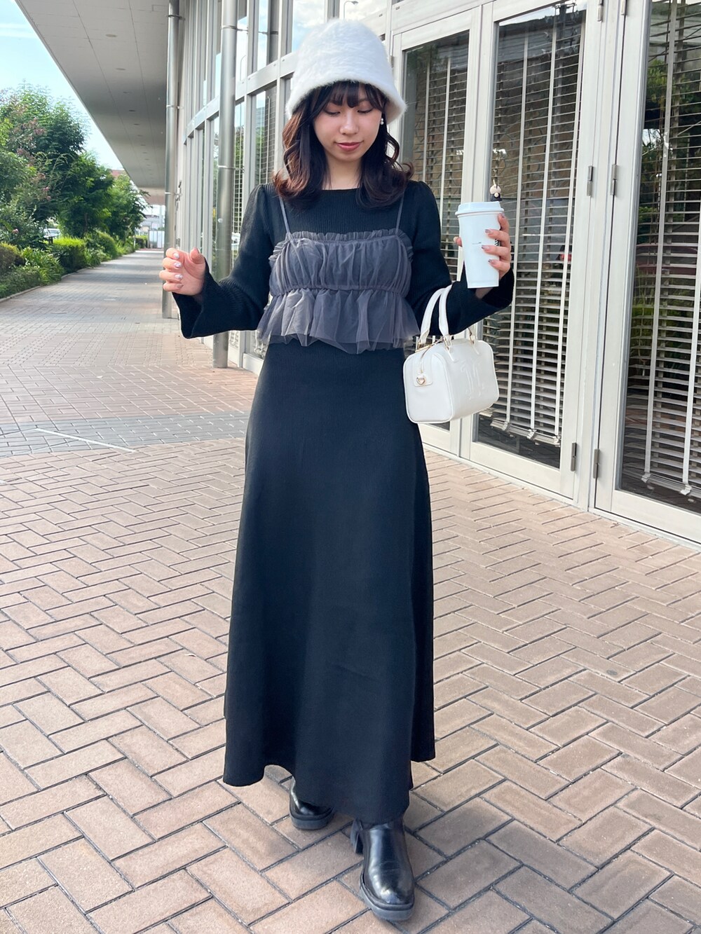 ブラック系のワンピース、ホワイト系のショルダーバッグ、ホワイト系のハットを着用したレディースの秋コーディネートの3枚目の写真