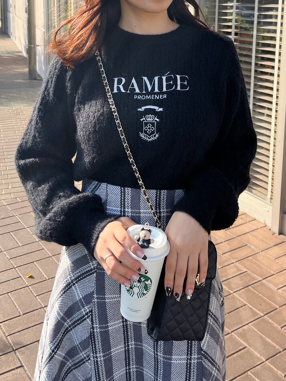 ブラック系のスカート、ブラック系のニット/セーターを着用したレディースの秋コーディネートの2枚目の写真