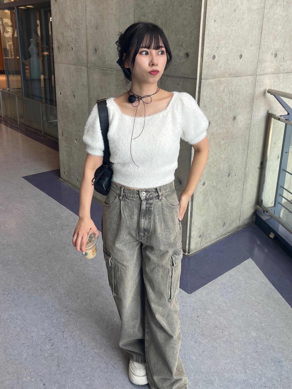 ブラック系のショルダーバッグ、ブラック系のカーゴパンツ、ホワイト系のスニーカーを着用したレディースの夏コーディネートの2枚目の写真