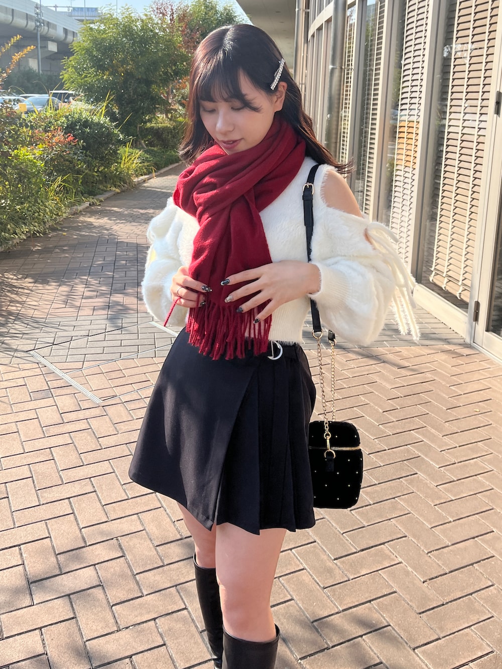 ブラック系のパンツ、ブラック系のショルダーバッグ、ホワイト系のニット/セーターを着用したレディースの冬コーディネートの2枚目の写真