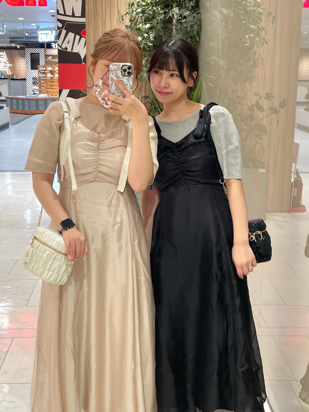 ブラック系のブーツ、ブラック系のショルダーバッグ、ブラック系のワンピースを着用したレディースの春コーディネートの2枚目の写真