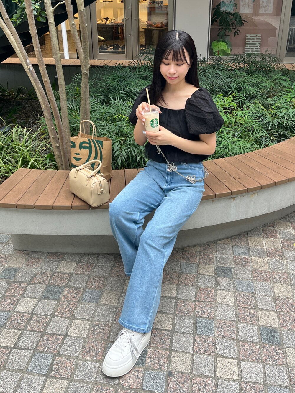 ブラック系のシャツ/ブラウス、ブルー系のデニムパンツ、イエロー系のショルダーバッグを着用したレディースの春コーディネートの2枚目の写真