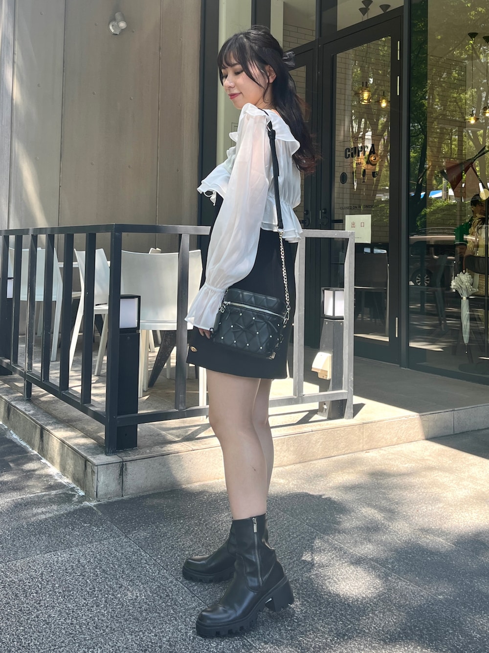 ホワイト系のワンピース、ブラック系のショルダーバッグを着用したレディースの夏コーディネートの2枚目の写真