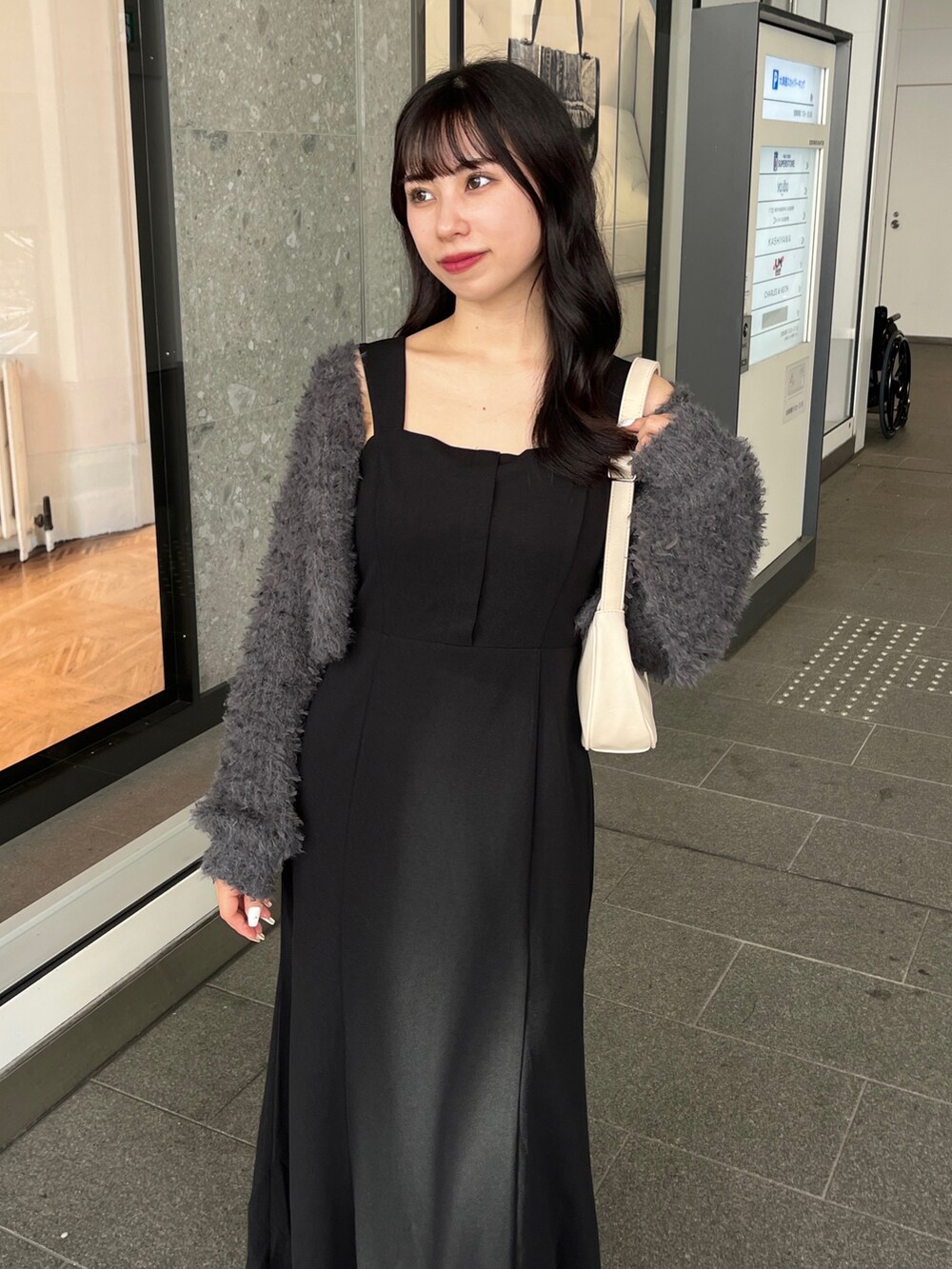 ブラック系のワンピース、グレー系のカーディガン/ボレロ、ブラック系のブーツを着用したレディースの秋コーディネートの2枚目の写真