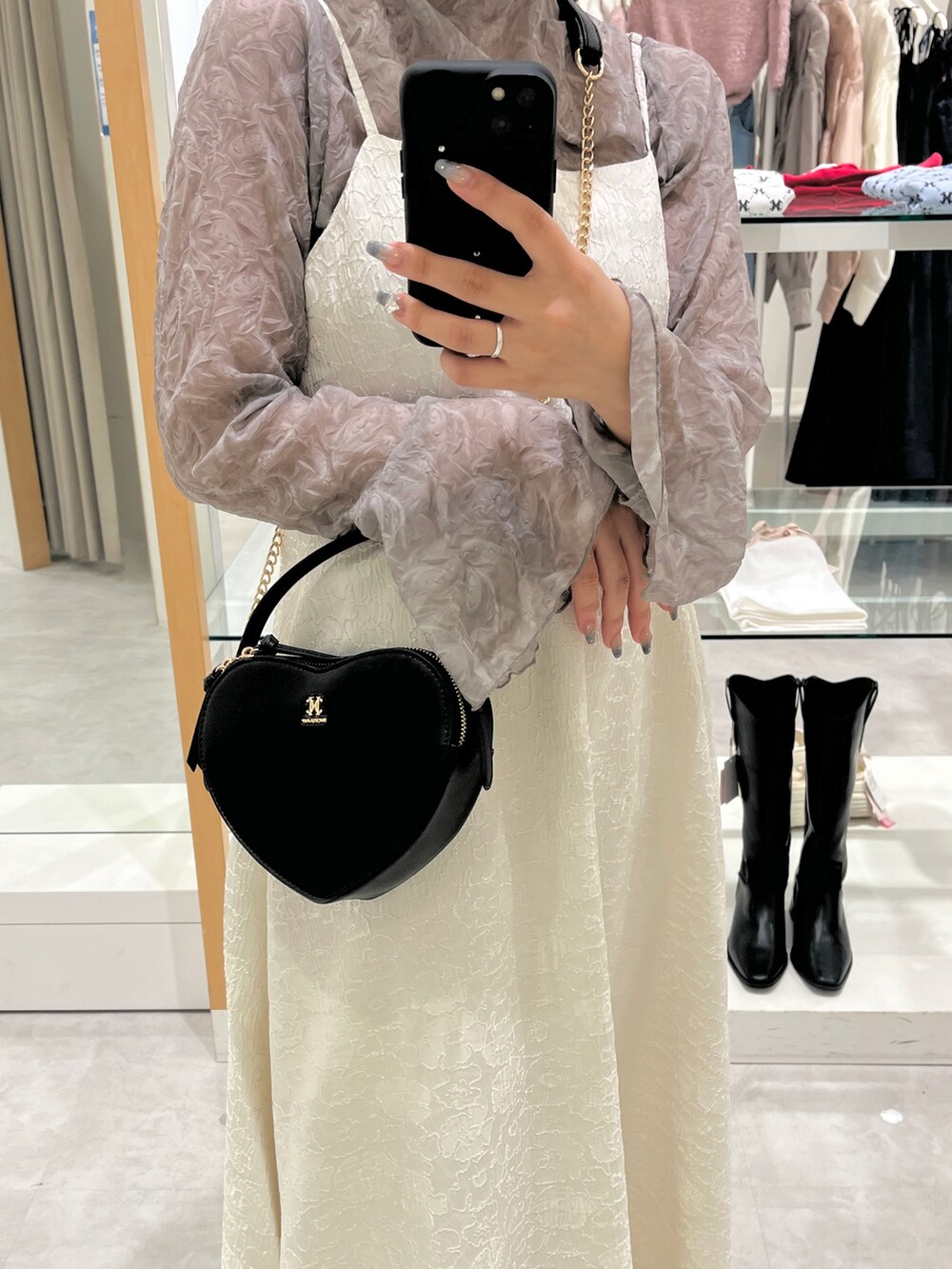 ホワイト系のスニーカー、ブラック系のショルダーバッグ、ホワイト系のワンピースを着用したレディースの夏コーディネートの2枚目の写真