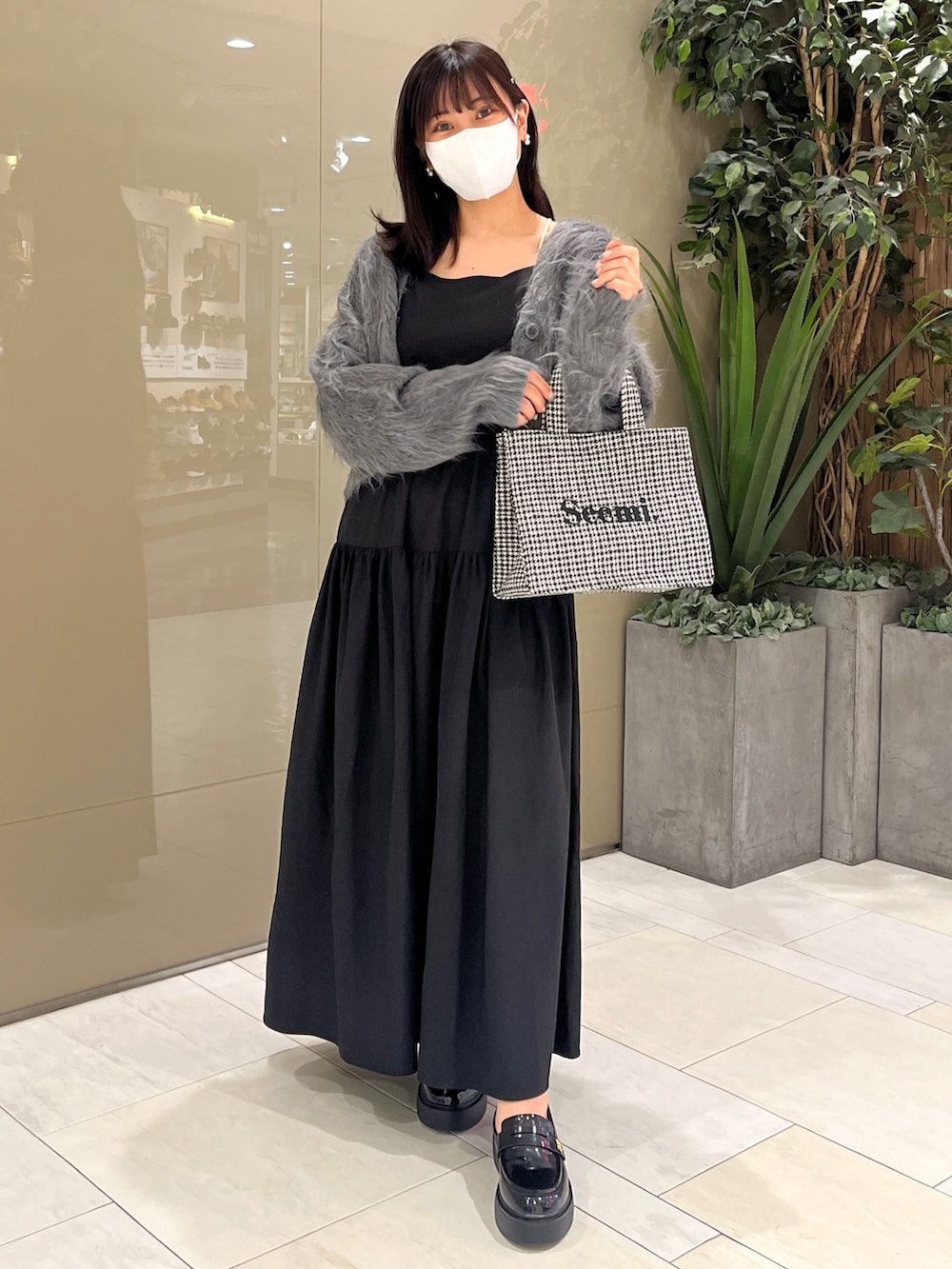 グレー系のカーディガン/ボレロ、ブラック系のワンピース、ホワイト系のトートバッグを着用したレディースの夏コーディネートの2枚目の写真