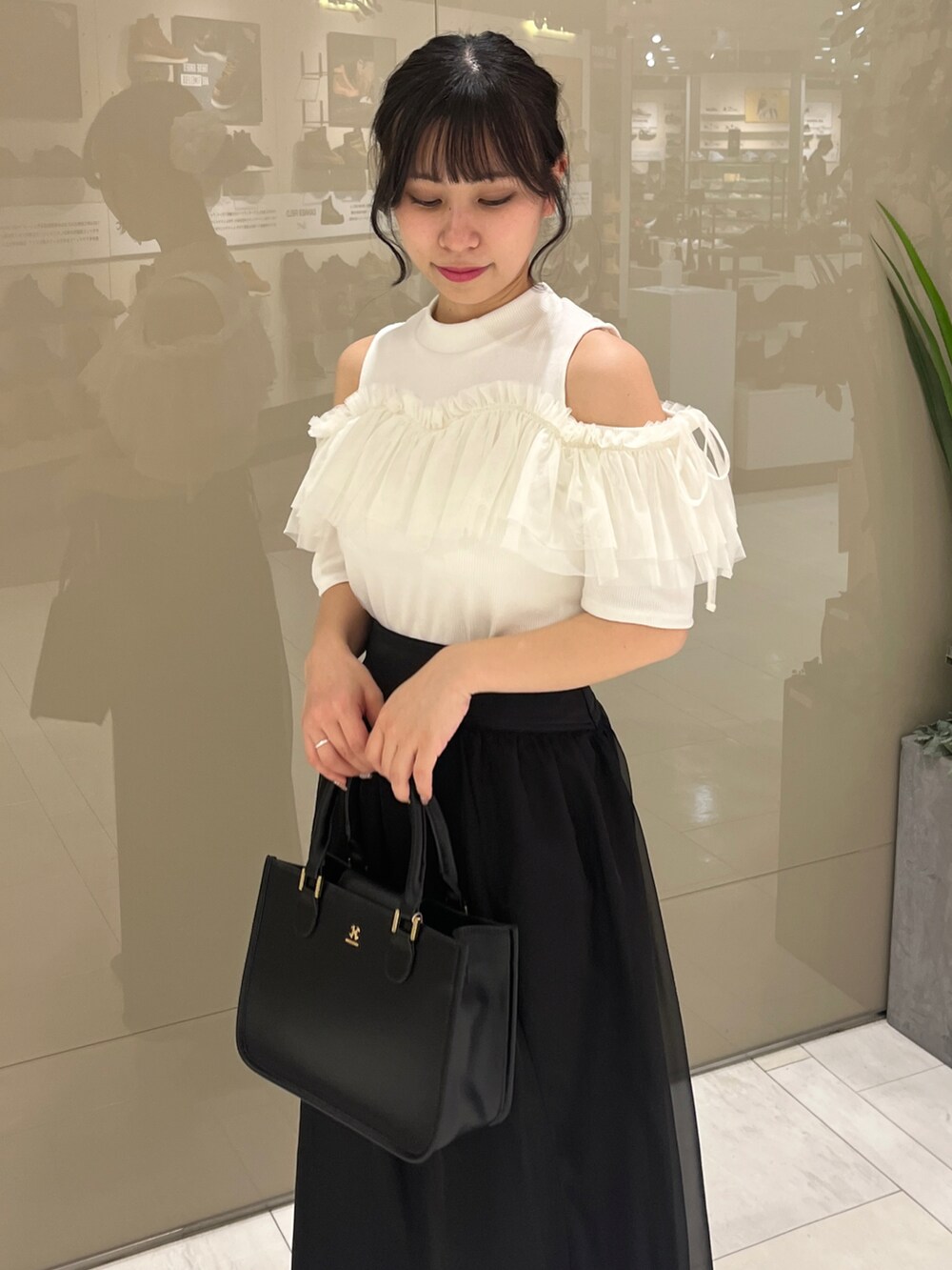 ホワイト系のTシャツ/カットソー、ブラック系のスカート、ブラック系のブーツを着用したレディースの春コーディネートの2枚目の写真