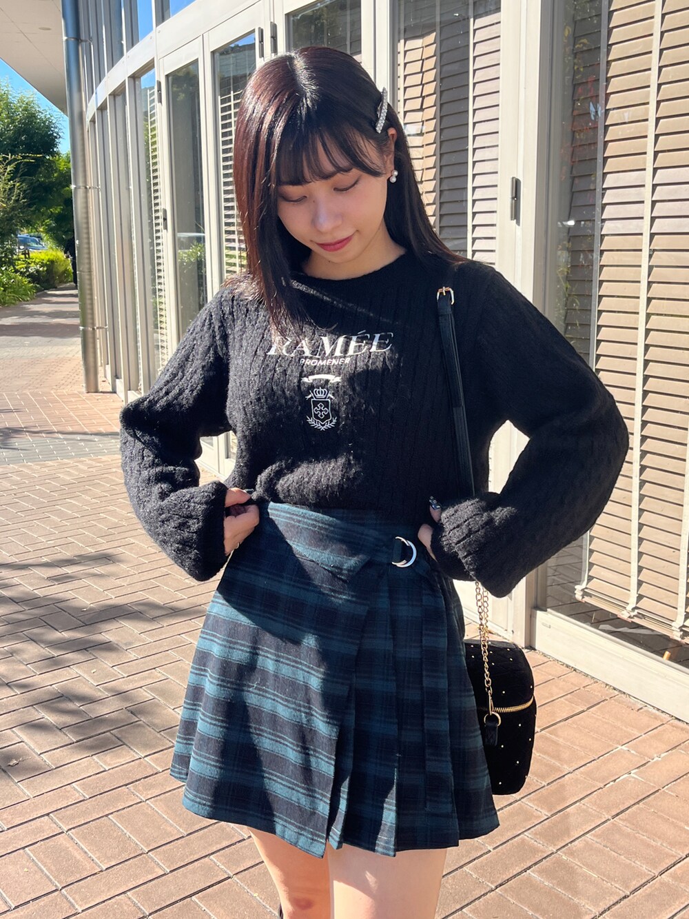 ブラック系のニット/セーター、グリーン系のパンツ、ブラック系のショルダーバッグを着用したレディースの秋コーディネートの2枚目の写真