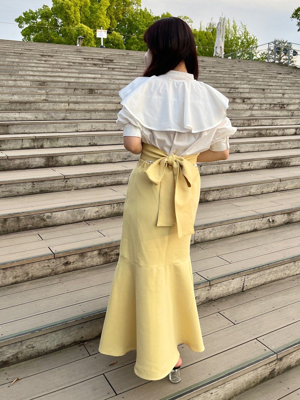 ホワイト系のシャツ/ブラウス、イエロー系のスカートを着用したレディースの春コーディネートの2枚目の写真