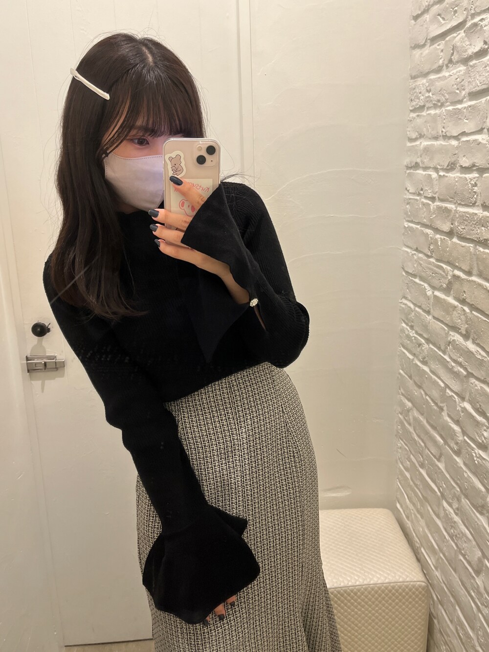 ブラック系のニット/セーター、ブラック系のスカート、ブラック系のブーツを着用したレディースの冬コーディネートの2枚目の写真