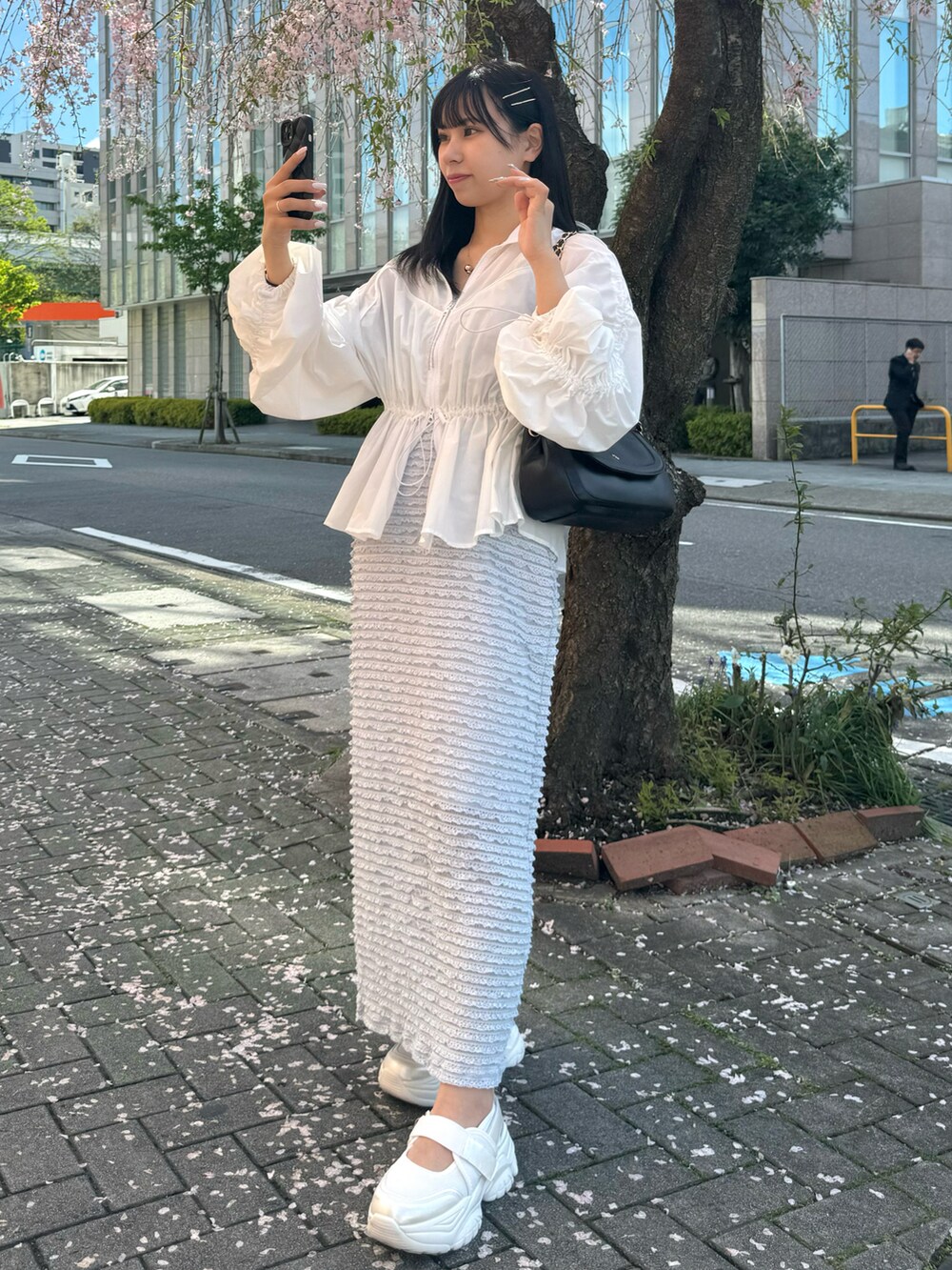 ホワイト系のシューズ、ホワイト系のマウンテンパーカー、ブルー系のワンピースを着用したレディースの春コーディネートの2枚目の写真