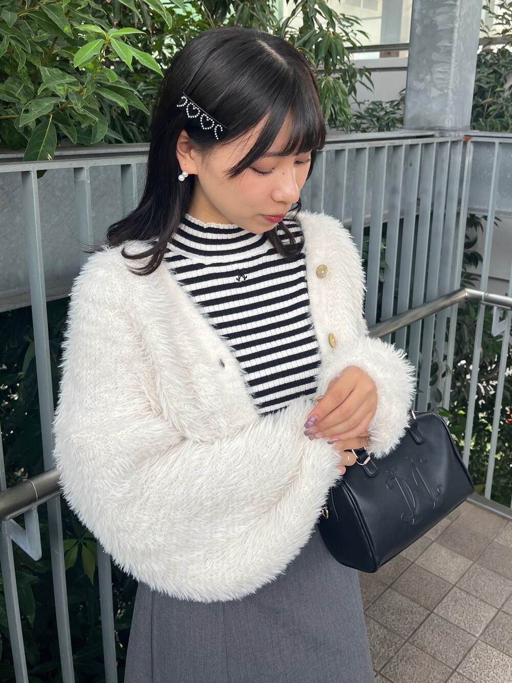 ホワイト系のニット/セーター、ホワイト系のカーディガン/ボレロ、グレー系のスカートを着用したレディースの秋コーディネートの2枚目の写真