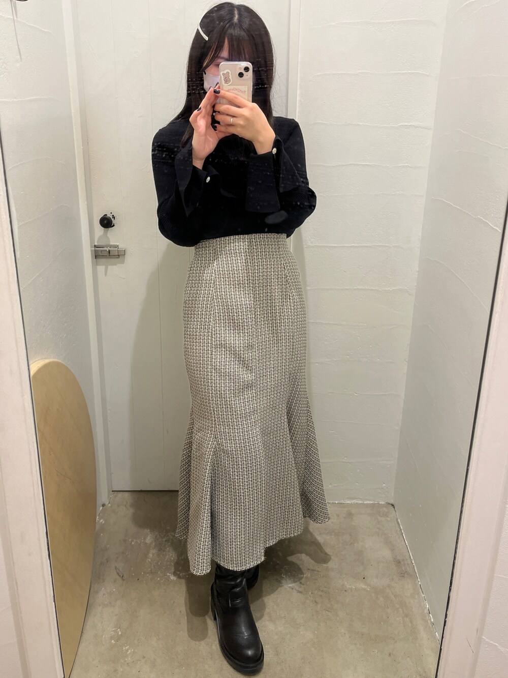 ブラック系のニット/セーター、ブラック系のスカート、ブラック系のブーツを着用したレディースの冬コーディネートの3枚目の写真