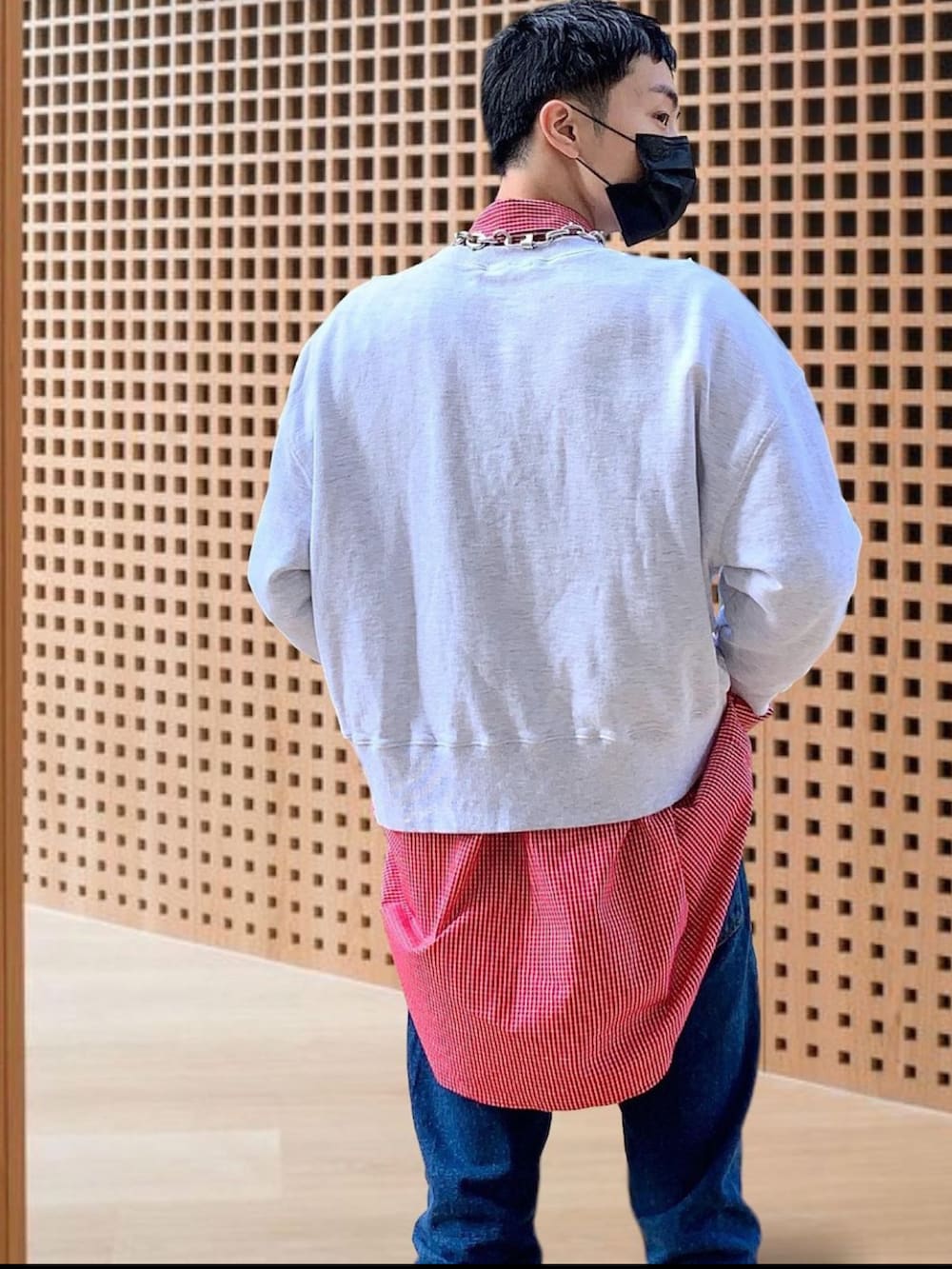 グレー系のトップス、レッド系のシャツ/ブラウス、ブルー系のデニムパンツを着用したメンズの春コーディネートの3枚目の写真