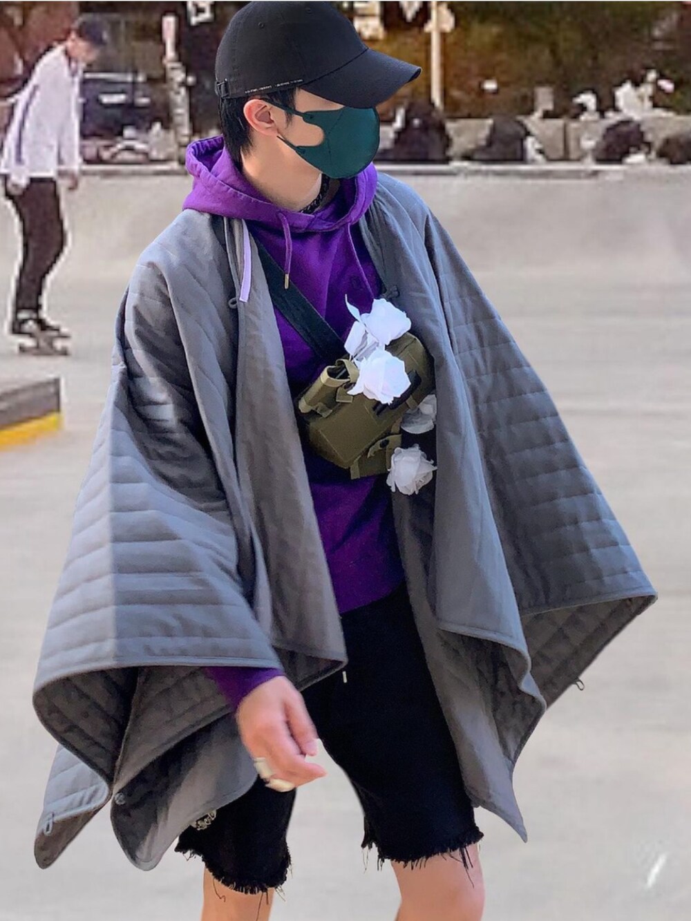 ブラック系のデニムパンツ、グレー系のポンチョ、パープル系のその他トップスを着用したメンズの春コーディネートの3枚目の写真