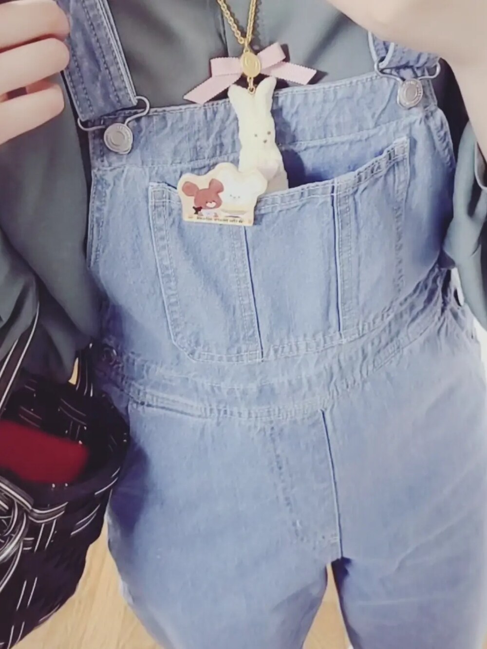 ブルー系のサロペット/オーバーオール、グリーン系のシャツ/ブラウス、ホワイト系のスリッポンを着用したレディースの春コーディネートの4枚目の写真