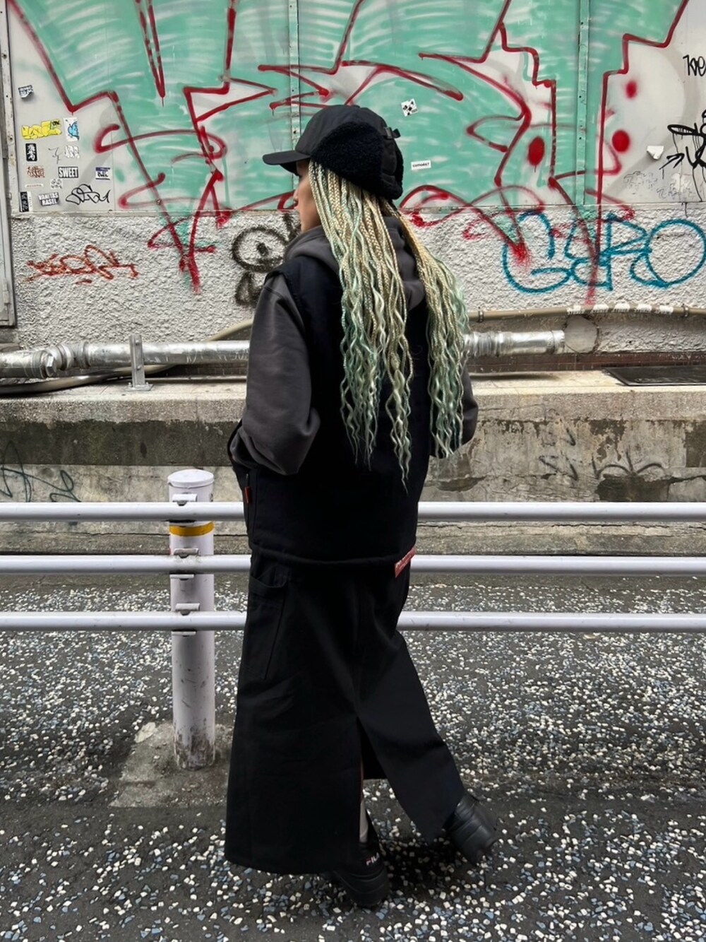 ブラック系のスカート、ブルー系のパーカー、ブラック系のベストを着用したレディースの秋コーディネートの2枚目の写真