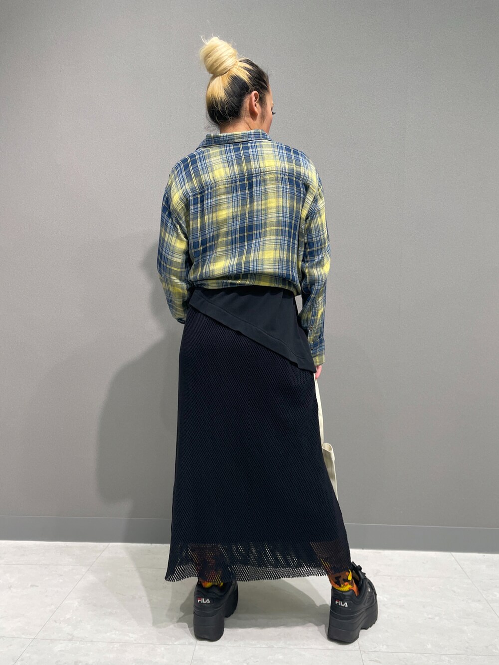 イエロー系のシャツ/ブラウス、ブラック系のワンピース、イエロー系のタンクトップを着用したレディースの春コーディネートの2枚目の写真